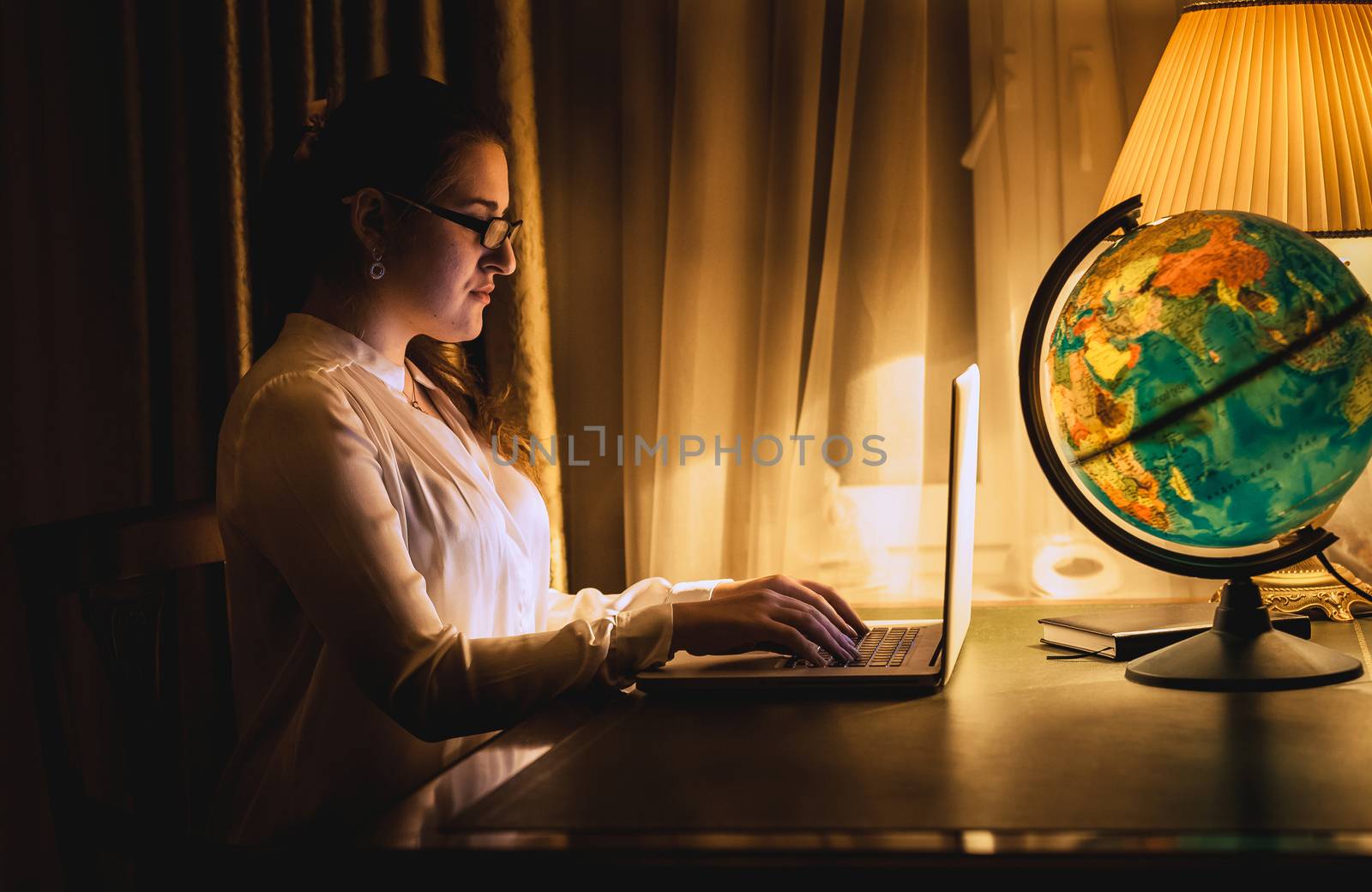 sexy woman working on laptop at dark room by Kryzhov