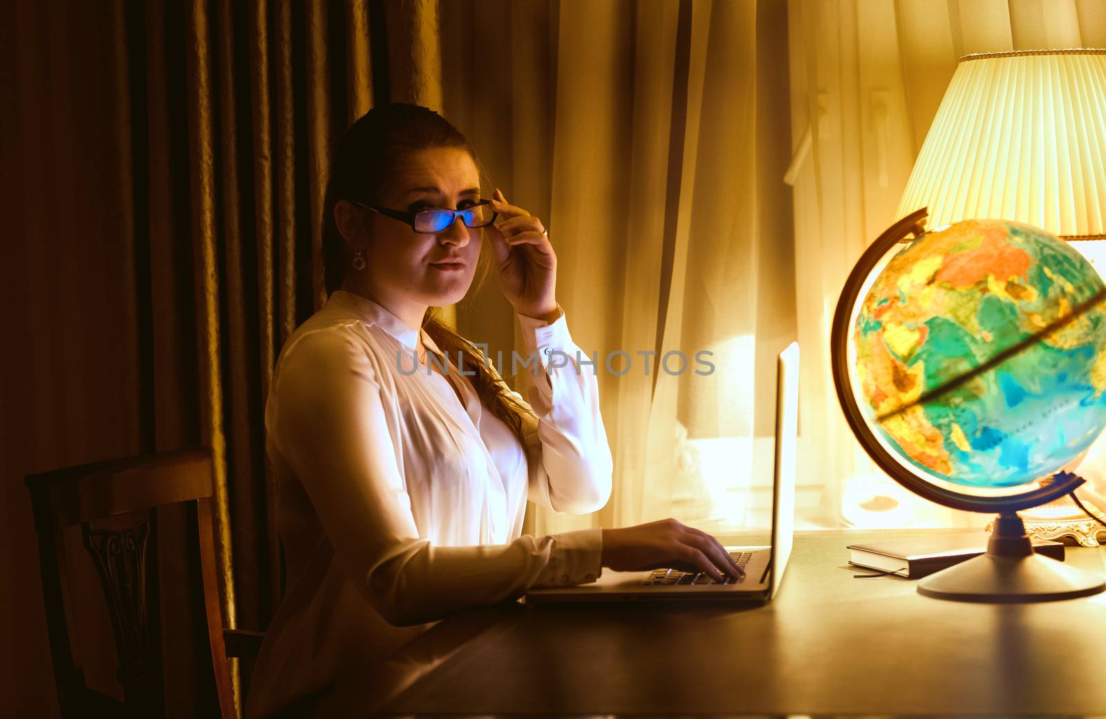 sexy woman in eyeglasses using laptop at classic interior