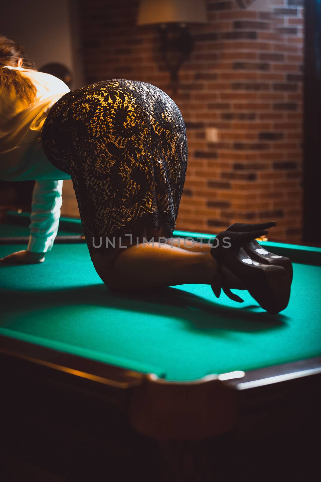 Photo of woman in skirt and stockings kneeling on billiard