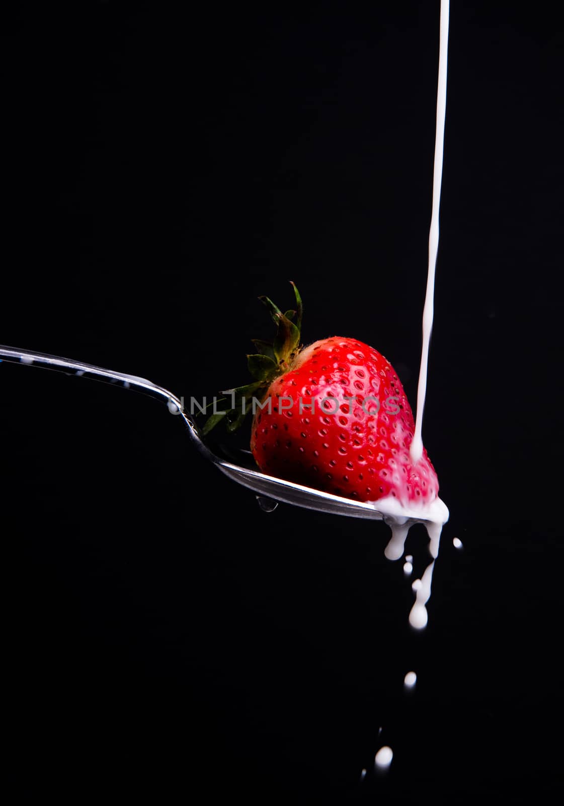 A piece of fruit in a spoon milk dropping