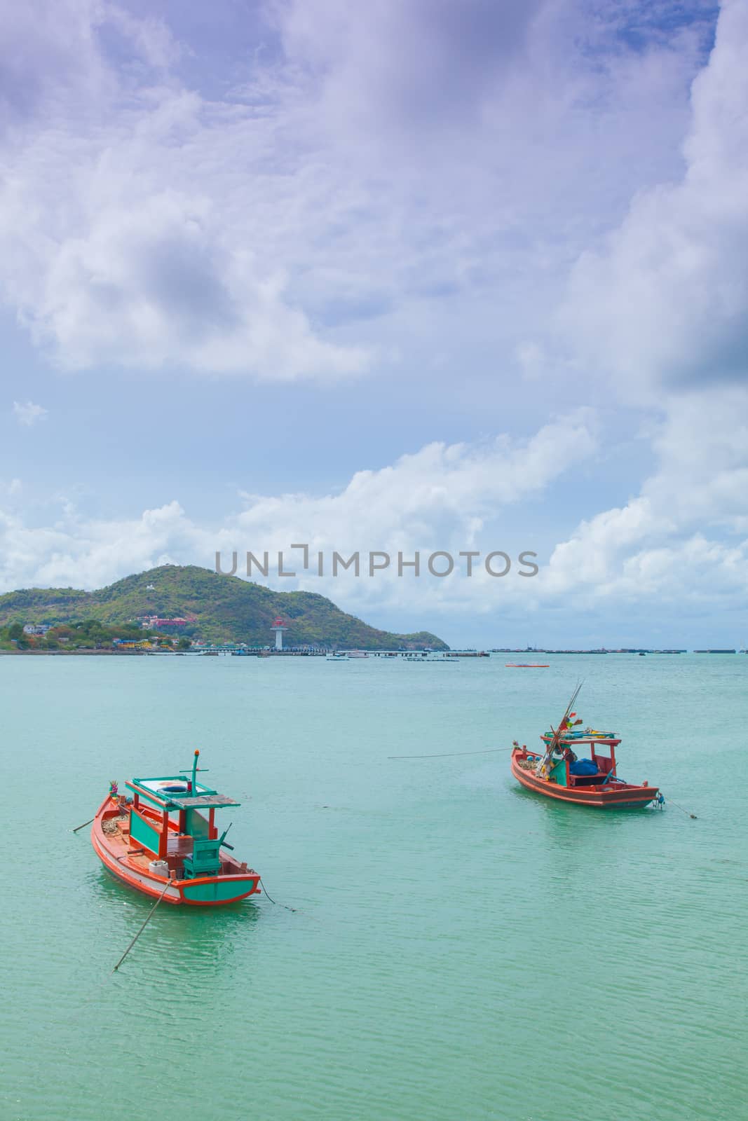 Small fishing boats moored in the sea. Behind the mountains and trees.