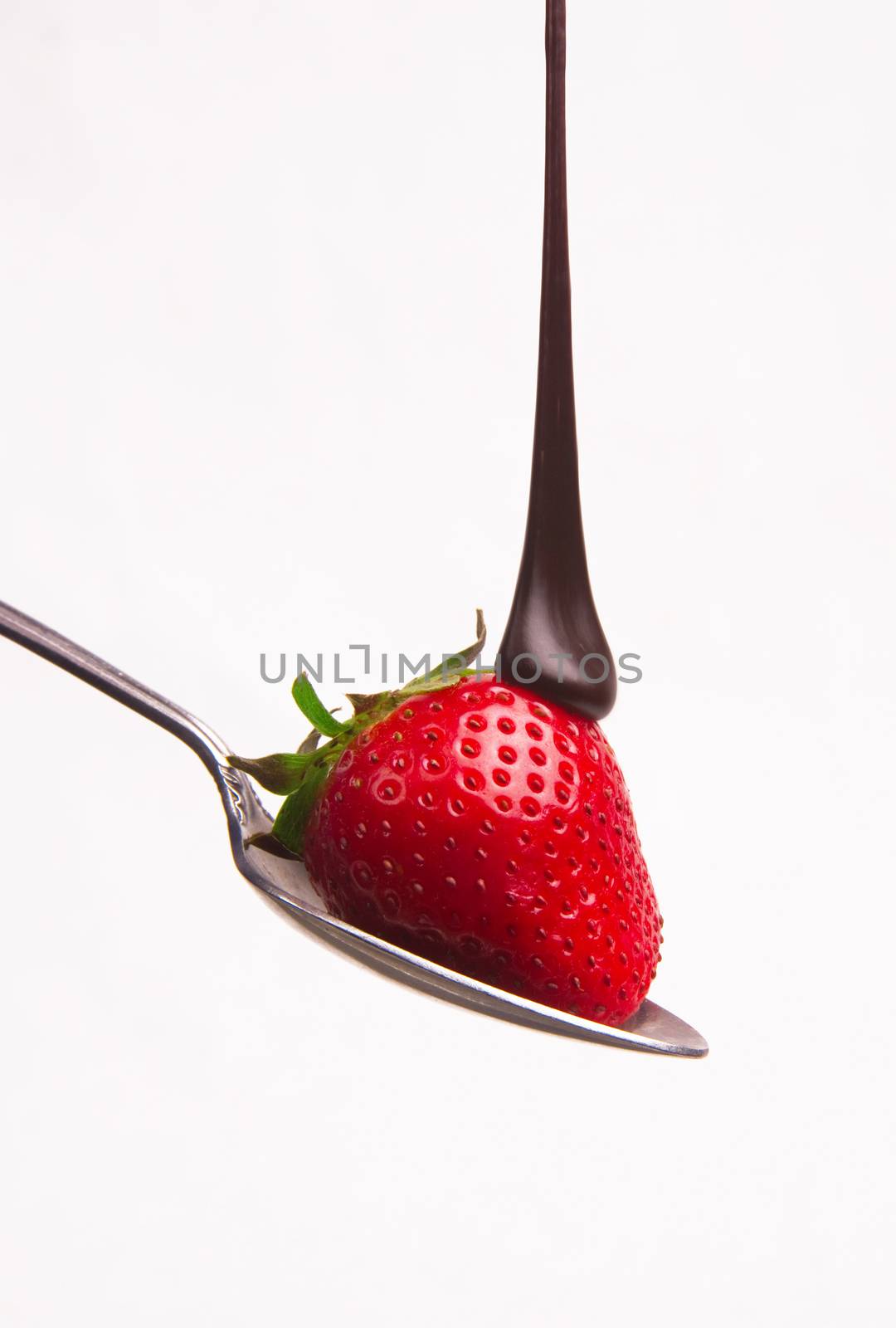 Chocolate sauce hits the berry on a spoon