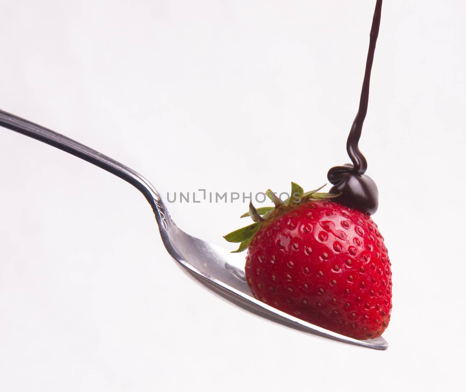 Chocolate sauce hits the berry on a spoon
