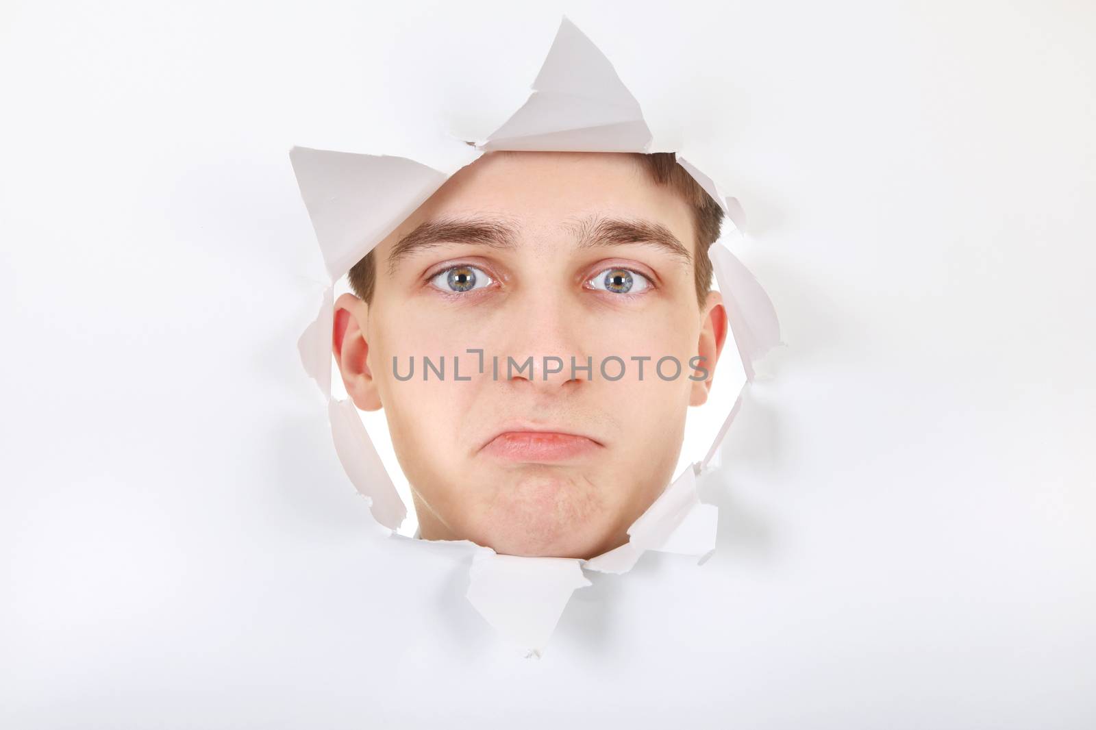 Sad Teenager peeking through Paper Hole