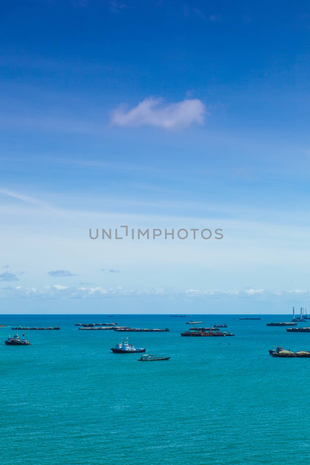Cargo ships. Moored offshore. In the daytime sky with little clouds.