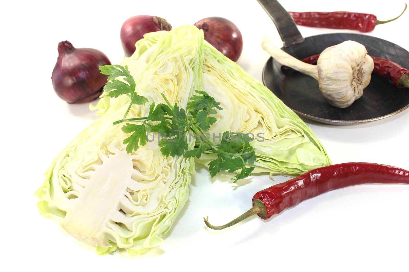 pointed cabbage with onions in a pan on a light background