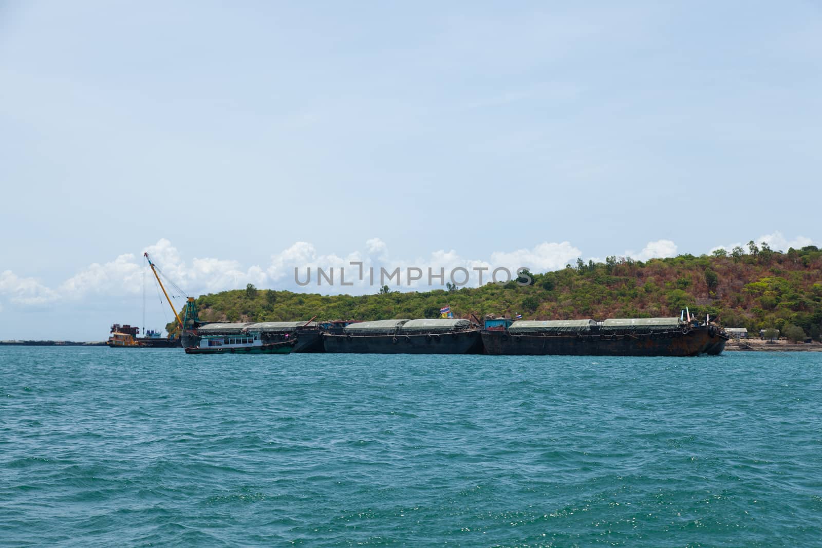 Large cargo ship. Moored at sea. Island near the docks.