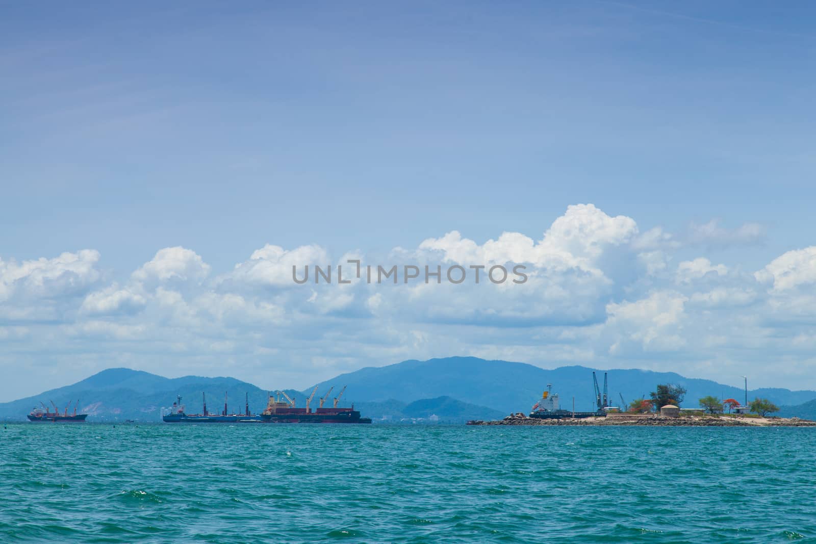 cargo ship Moored near the island behind a mountain.