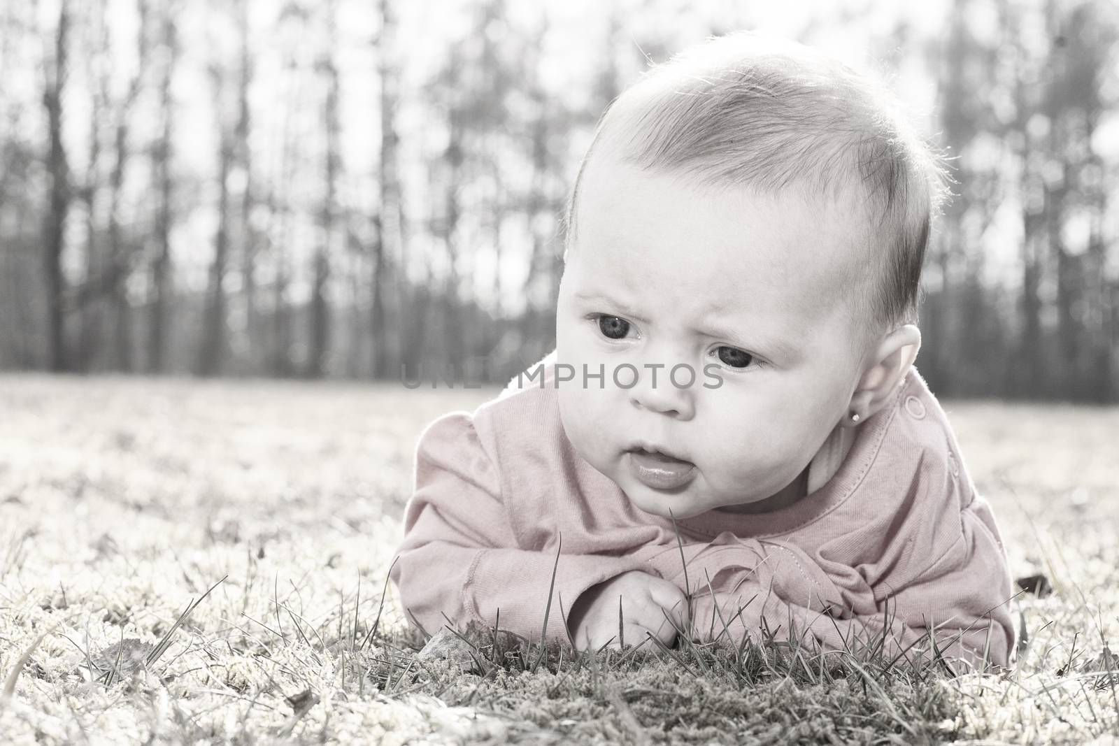 Little baby on the grass in the sun