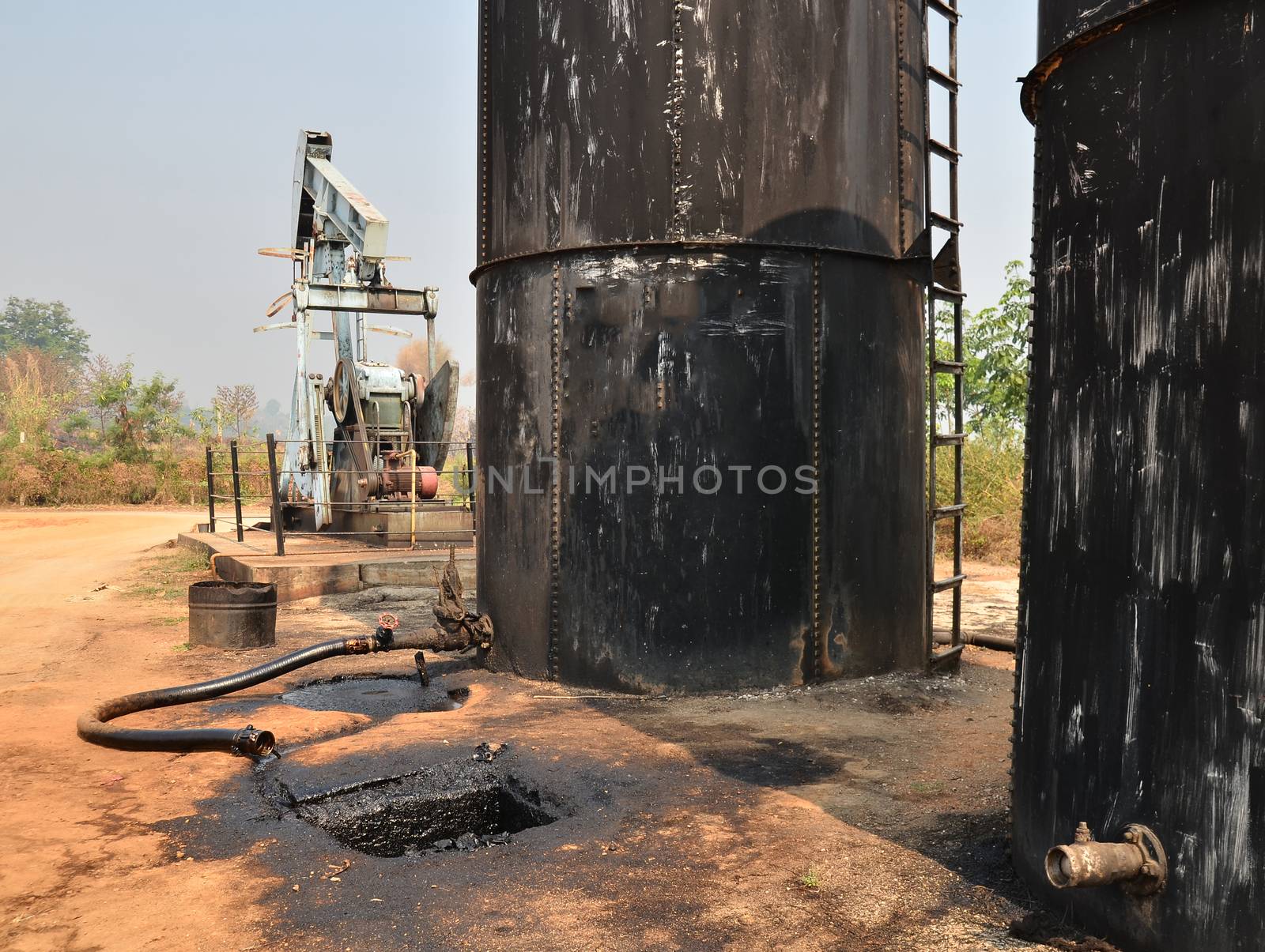 old pumpjack pumping crude oil from oil well