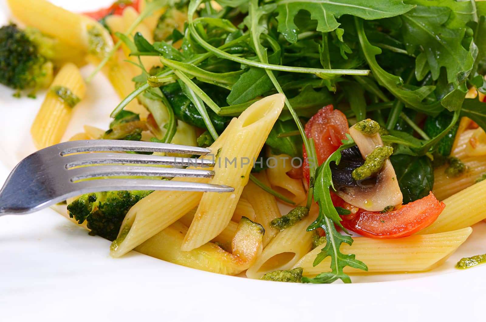 pasta with vegetables and salad close up