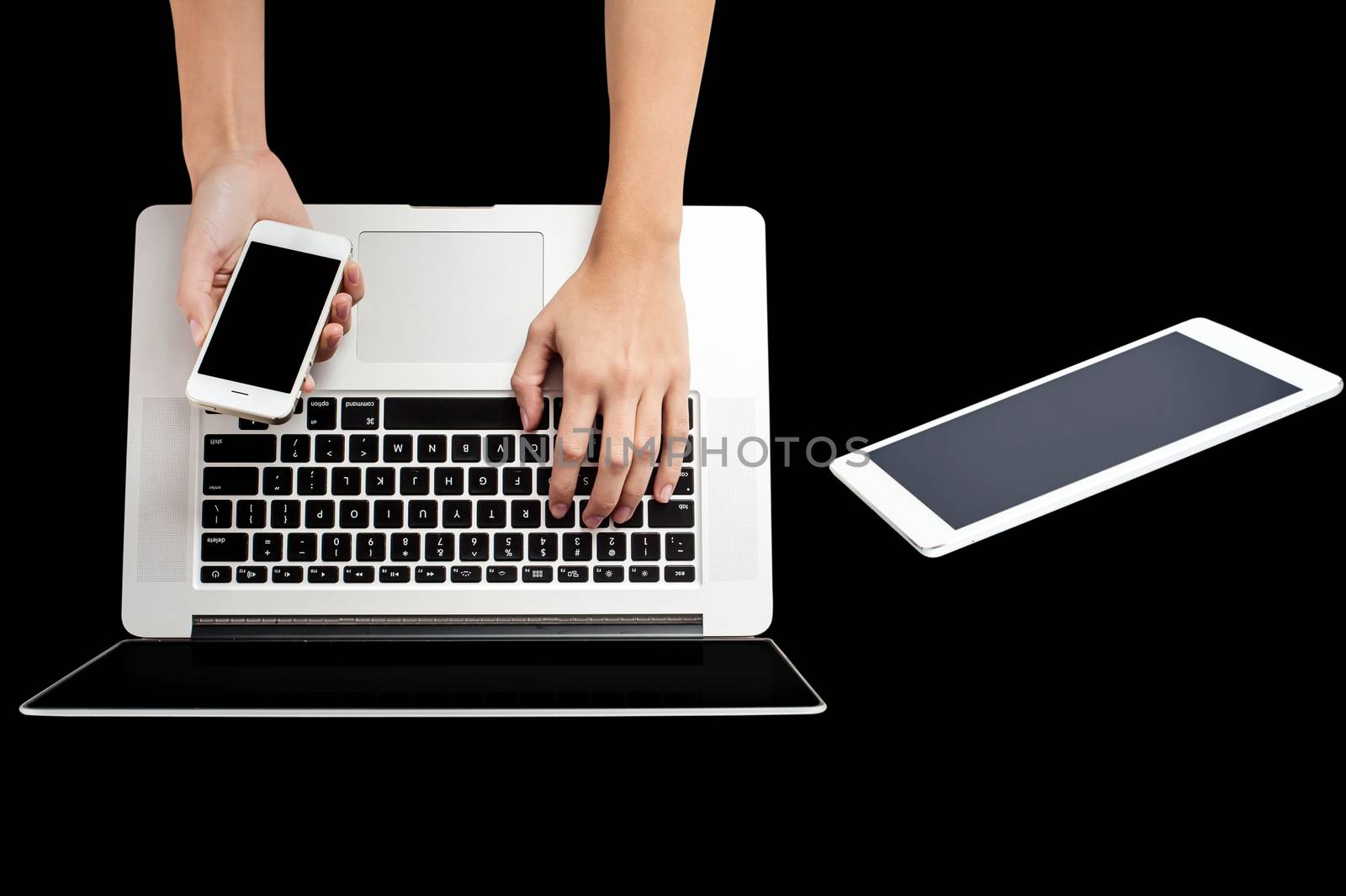 Woman hand holding mobile phone and working in laptop