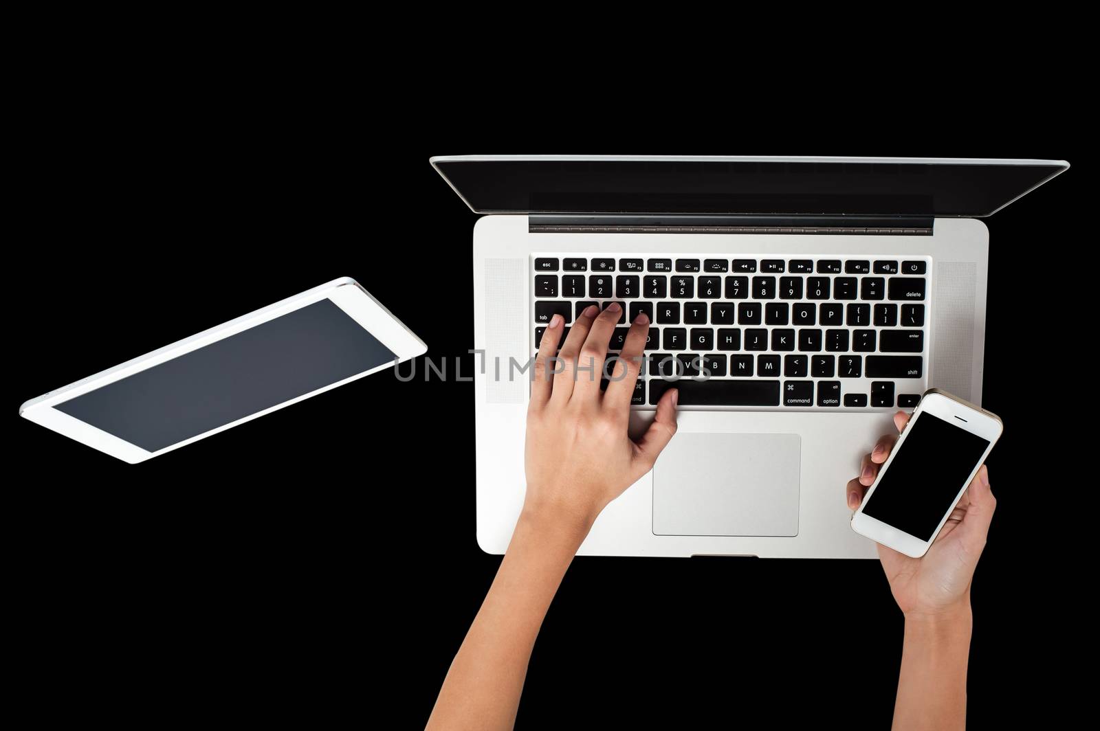 Woman hand working on laptop, holding a smartphone by stockyimages
