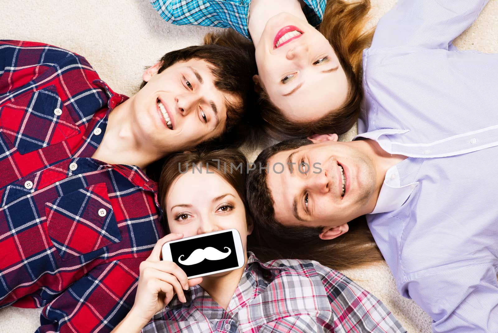 four young men lie together, young attractive woman pressed her lips to the phone