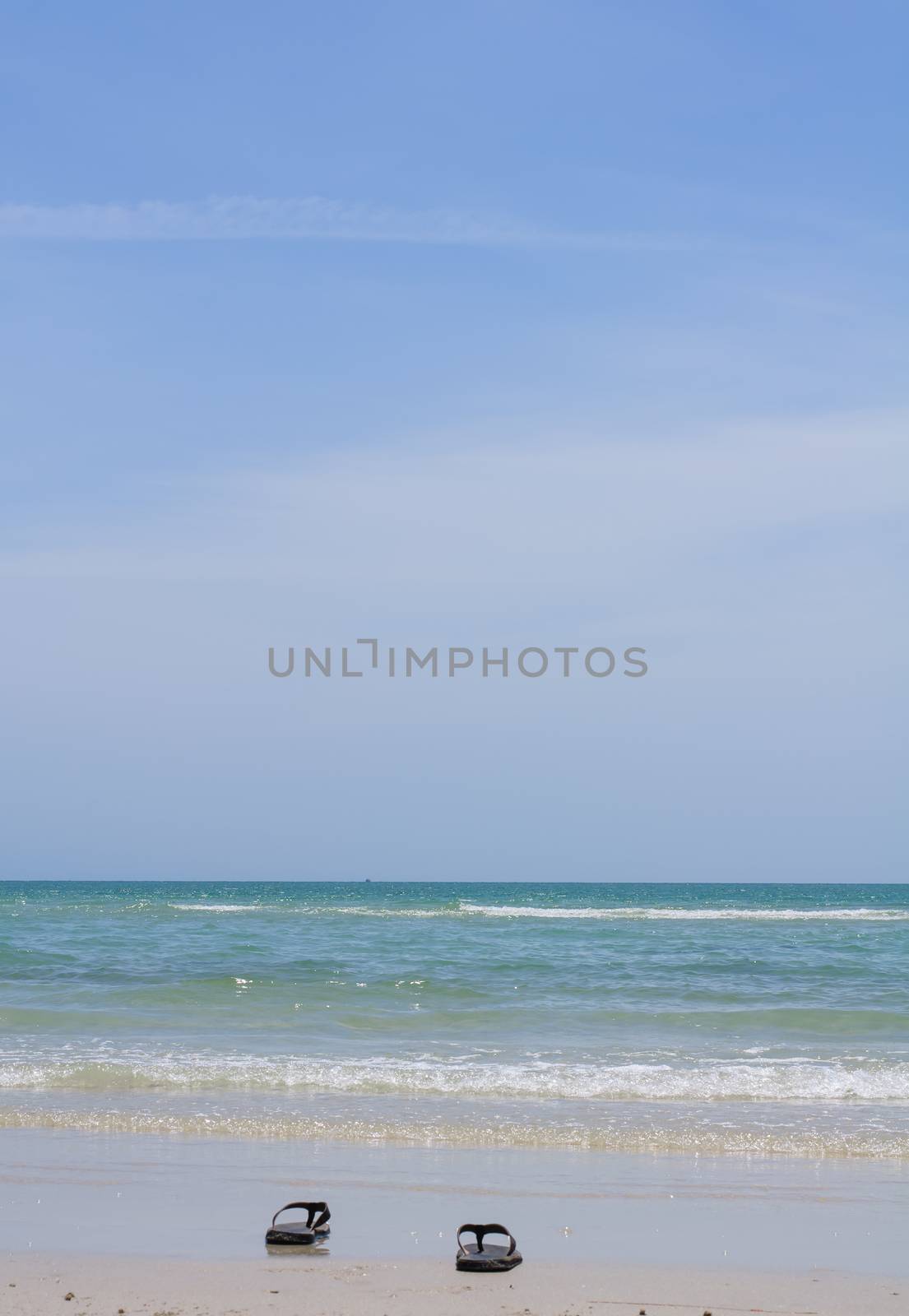 Beach slippers beside the sea and sunlight soft