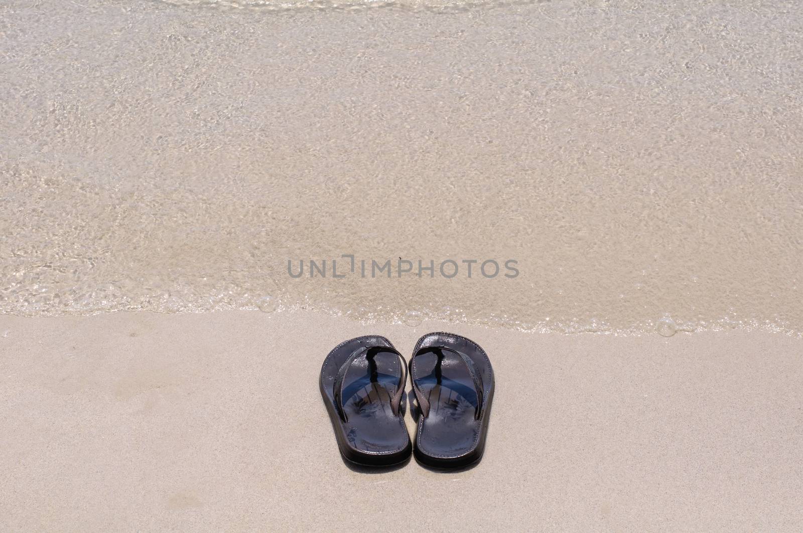 Beach sandals on a sandy beach with background