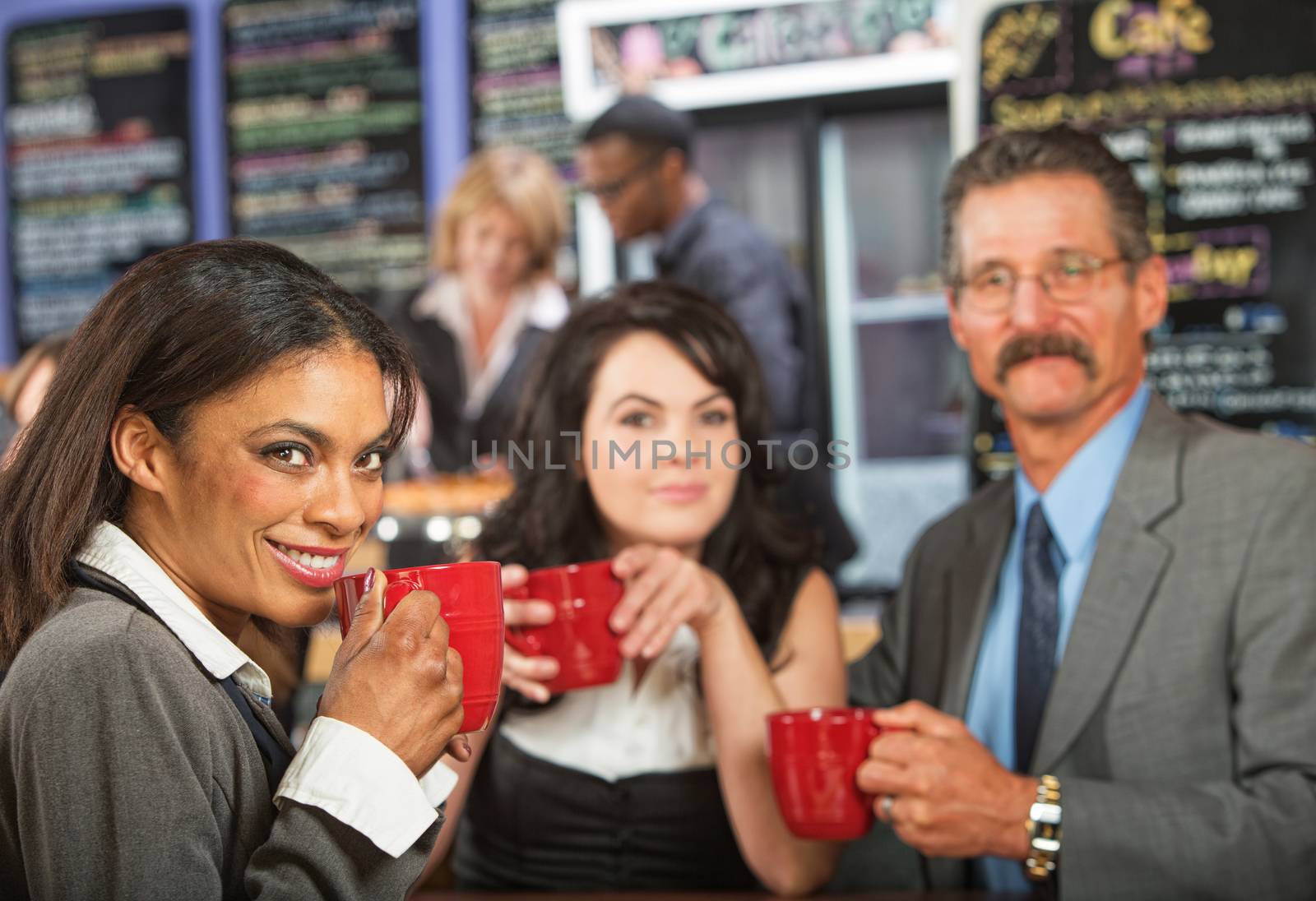 Three cheerful business people meeting at indoor cafe
