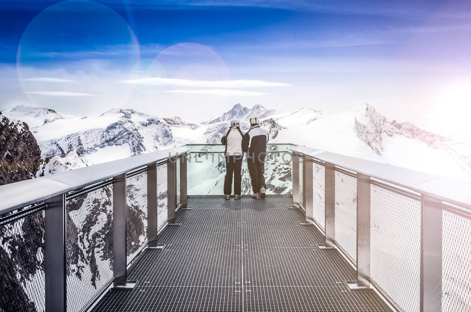 Two people looking at Alps mountains from viewpoint platform, Kaprun area, Austria