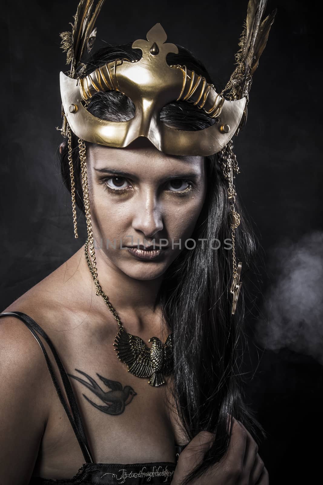 Sensual young woman with golden mask jewelry