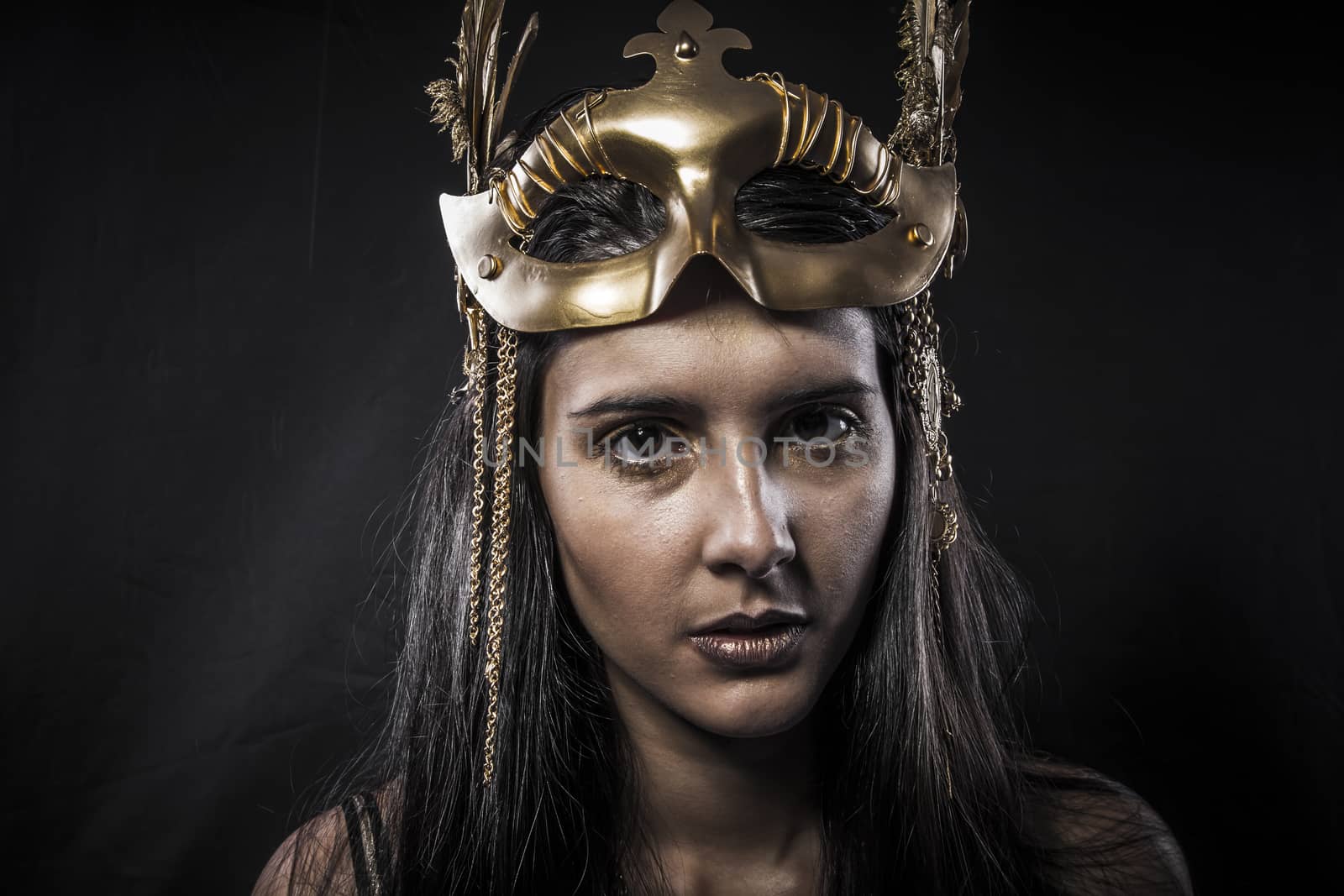 Sensual young woman with golden mask jewelry