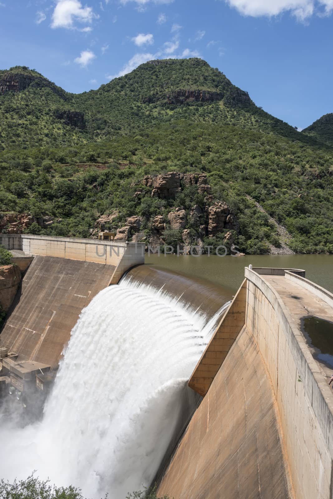 the swadini dam waterfall near the blyde river with the dragensberg as background