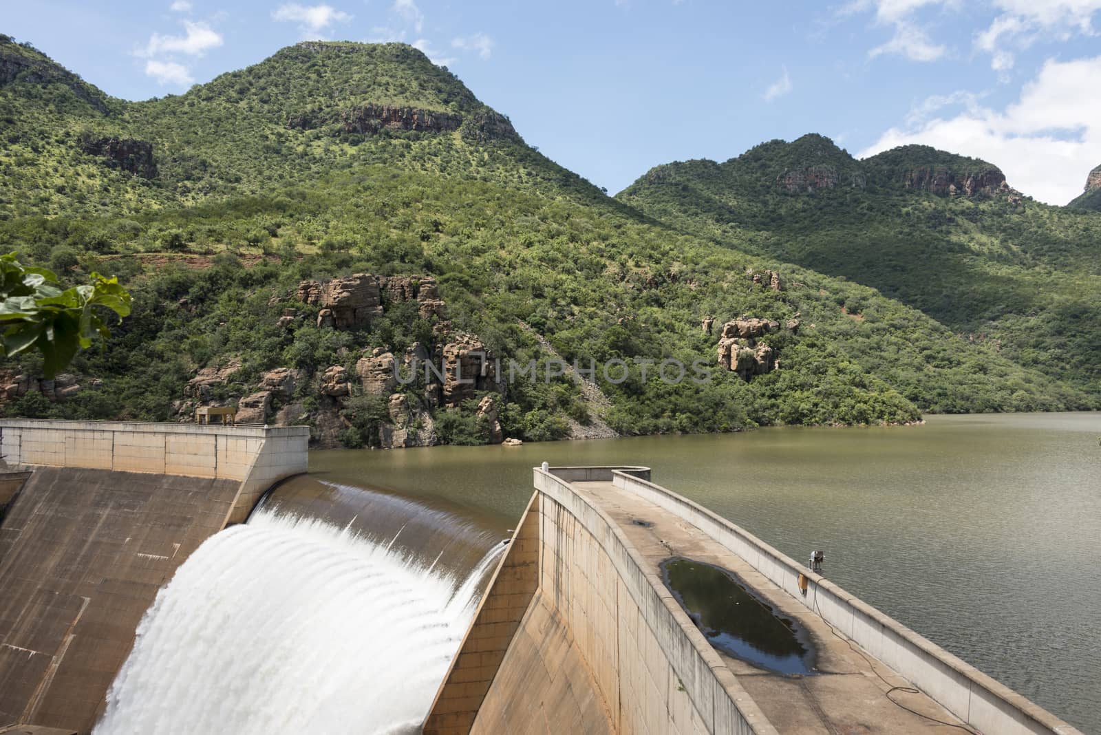 the swadini dam waterfall near the blyde river with the dragensberg as background
