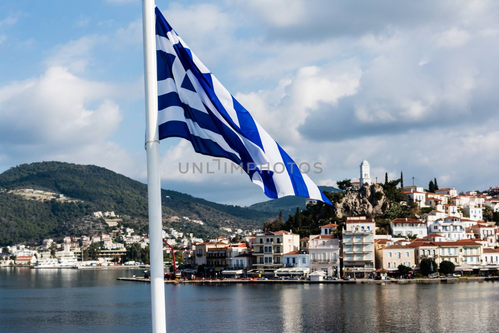 Greece, island of Poros behind a Greek Flag