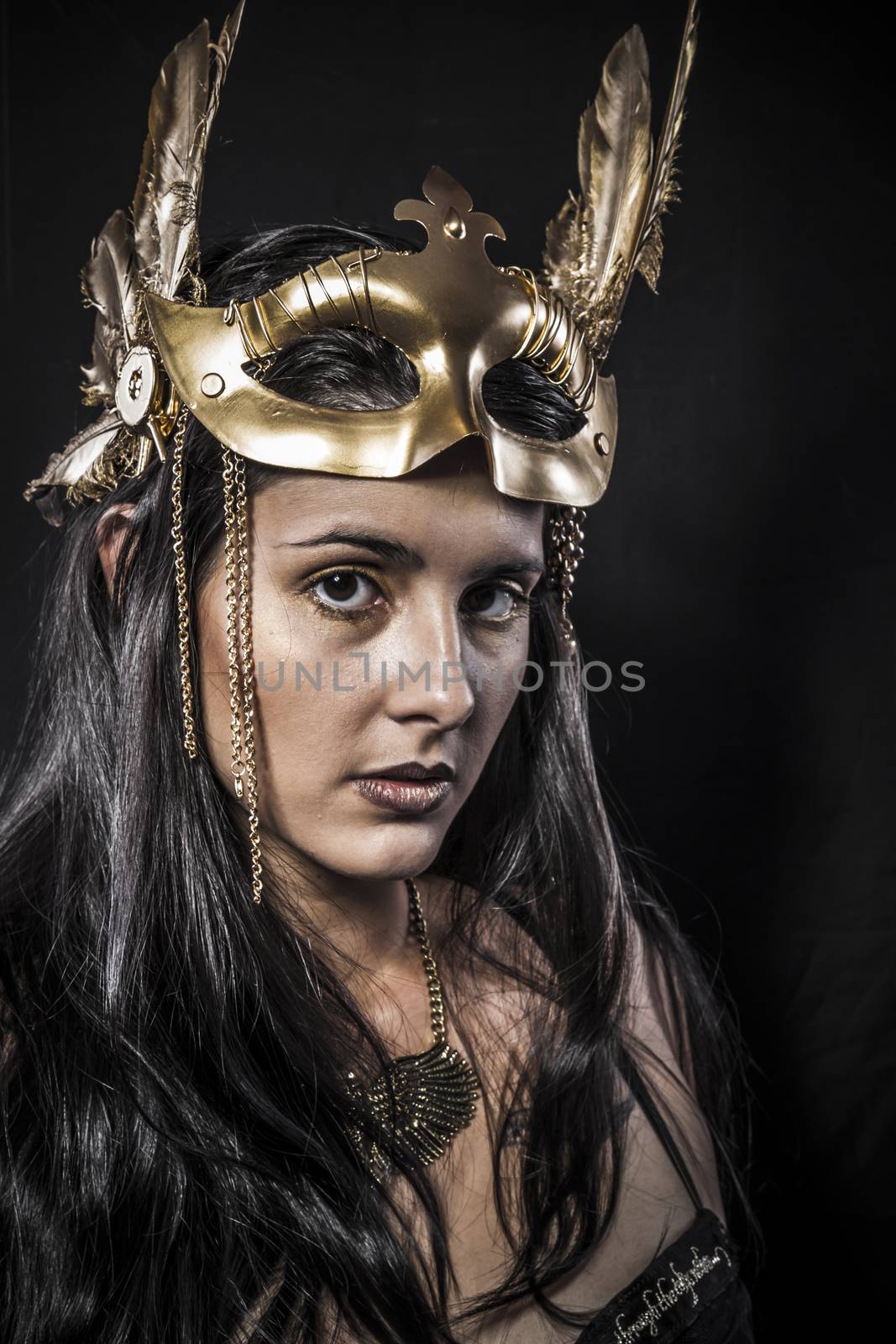 Sensual young woman with golden mask jewelry