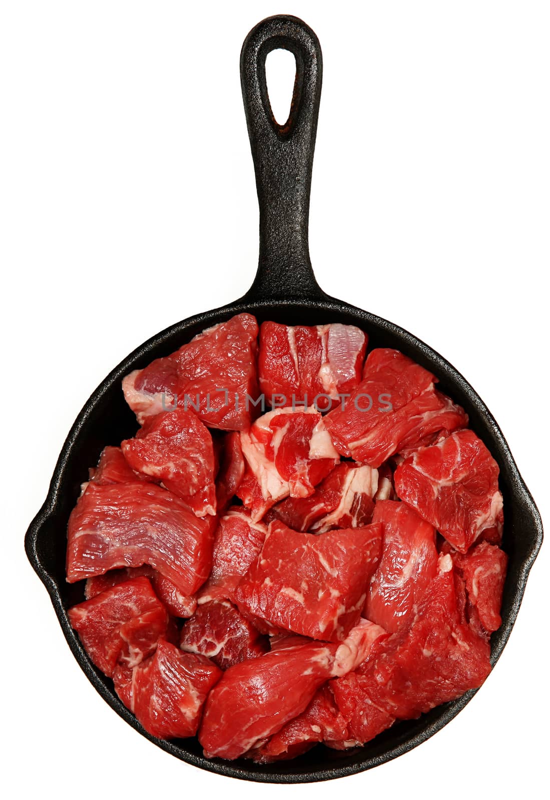 Raw Beef Cubes Chopped in Cast Iron Skillet Over White by duplass