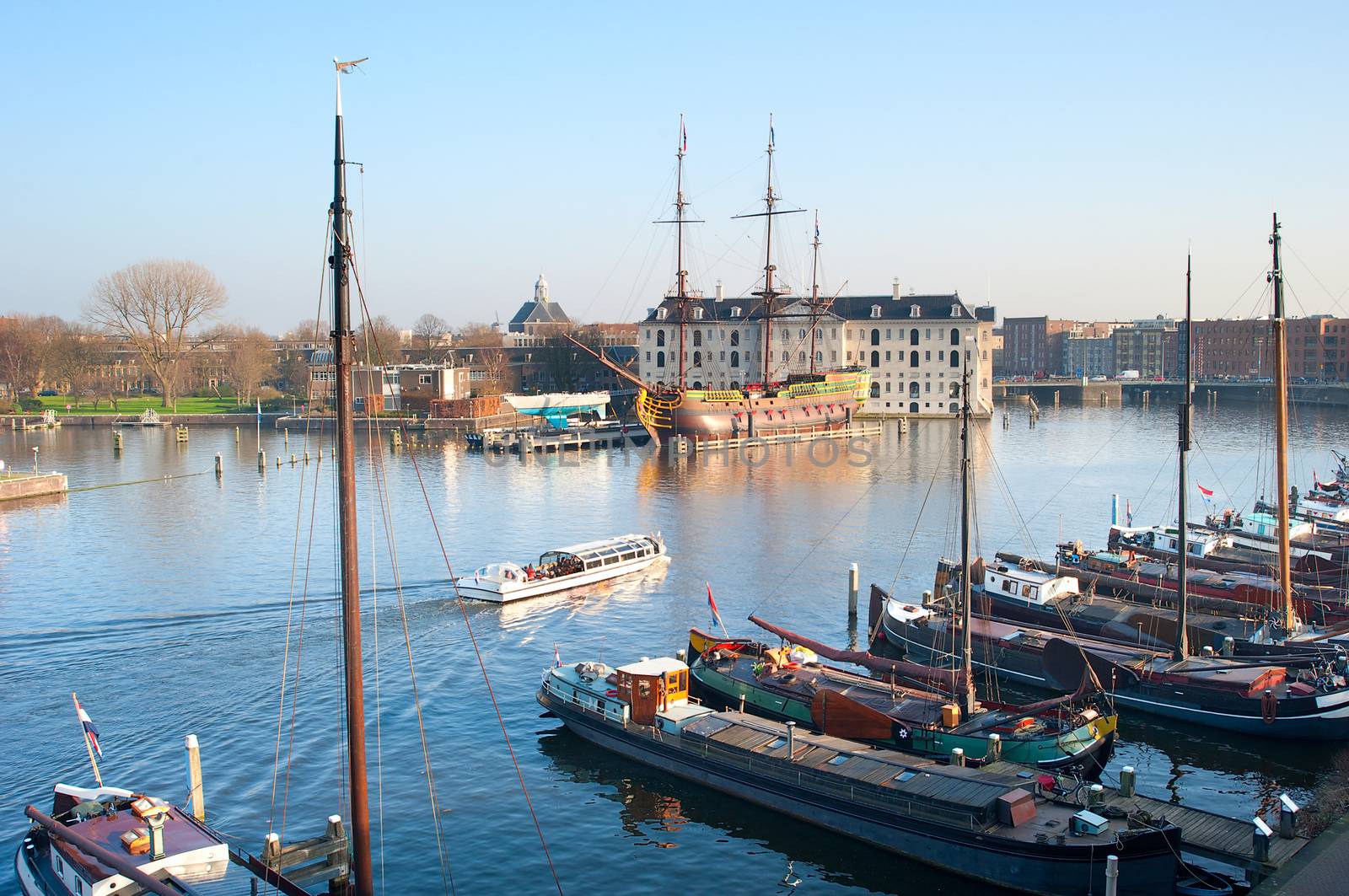 Water excursion by the Amstel river in Amsterdam, Netherlands. National Maritime Museum in the background