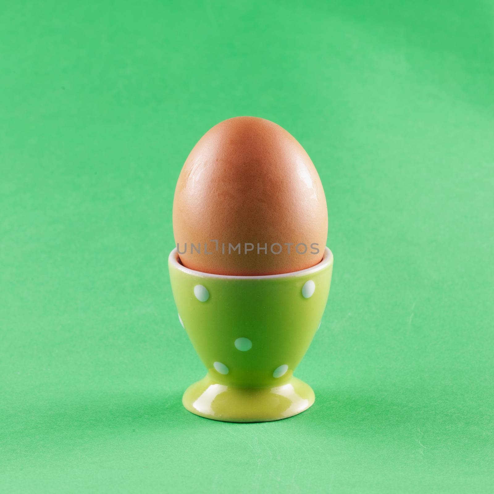 Egg in eggcup over a green background