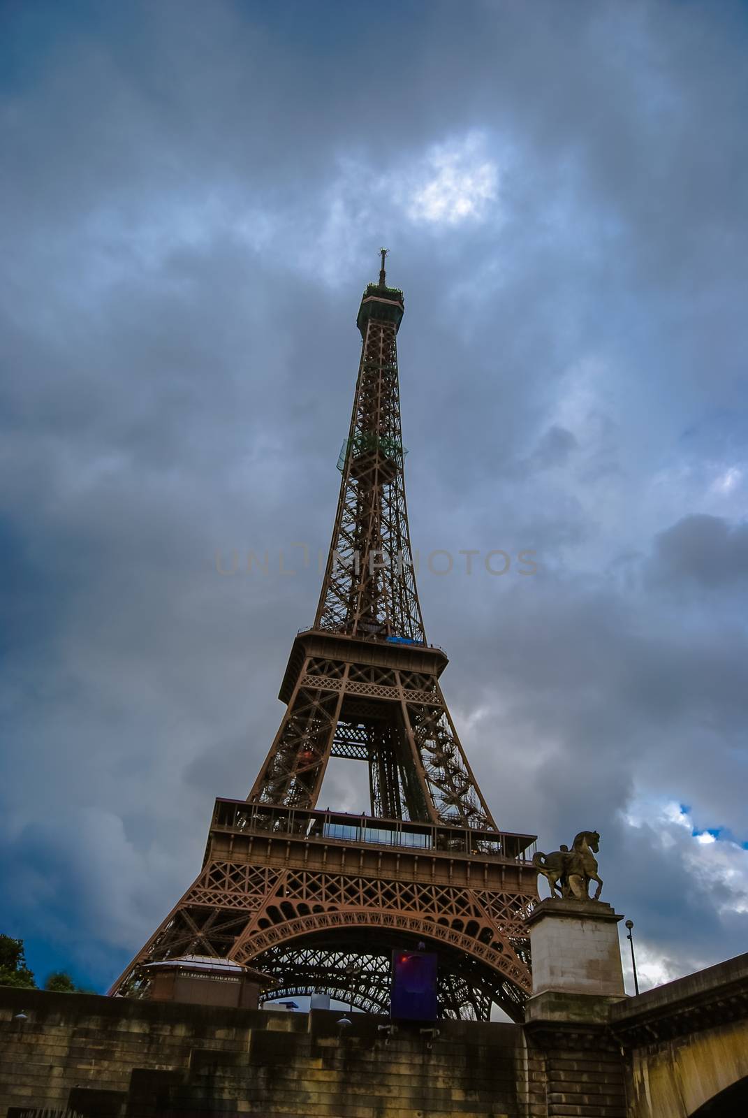 Eiffel tower at dusk, above clouds. viewd from seine