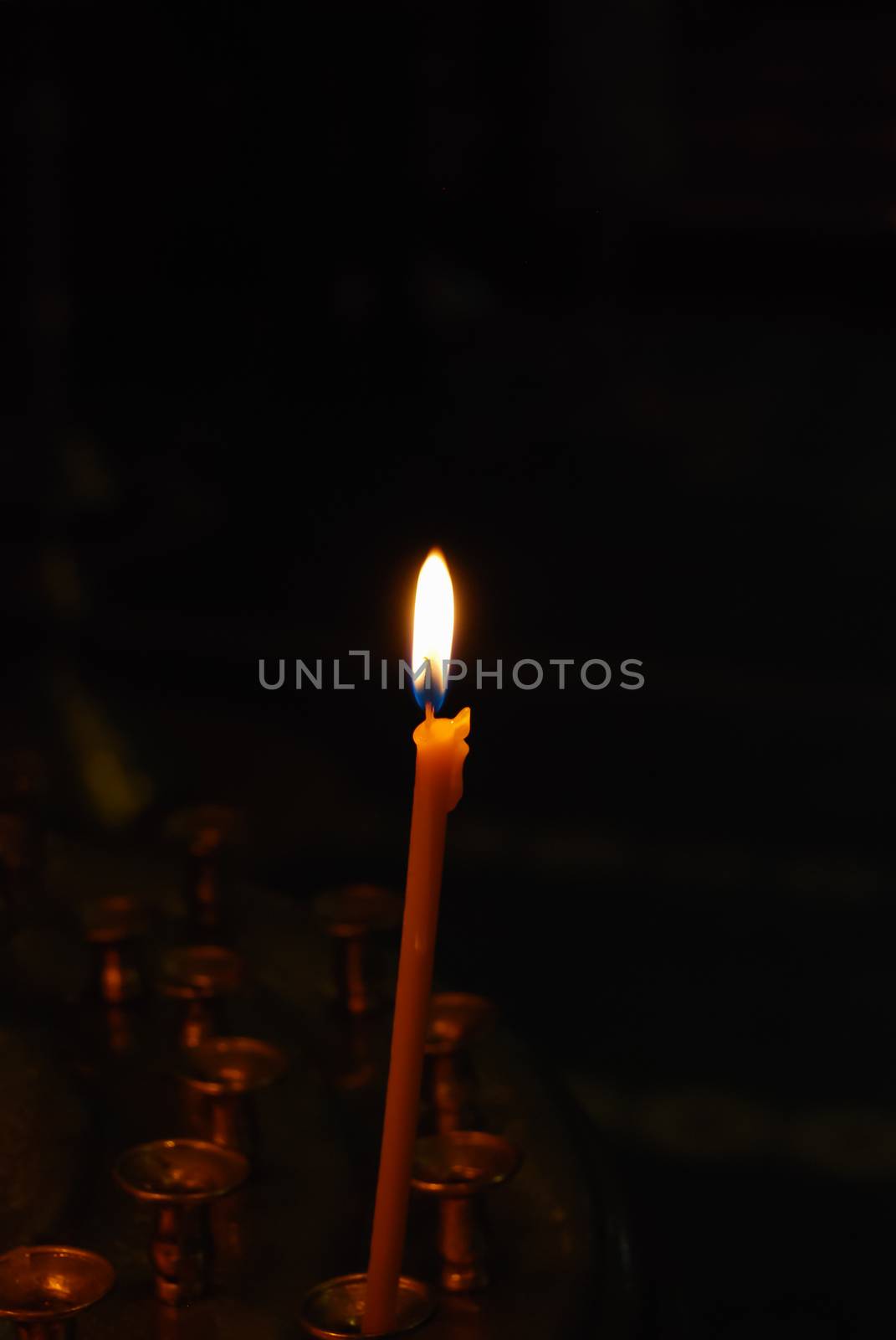 candle burns near icons in orthodox church