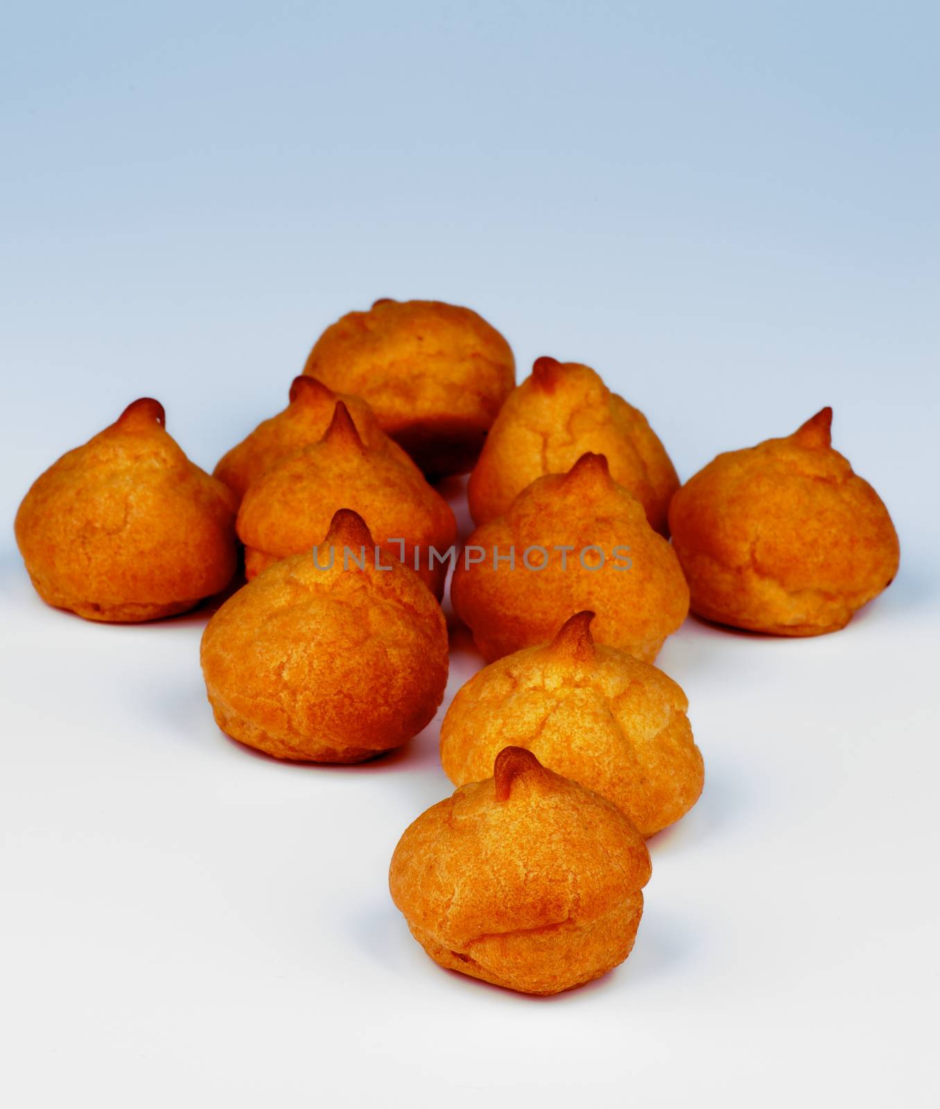 Heap of Freshly Baked Profiteroles isolated on Blue background