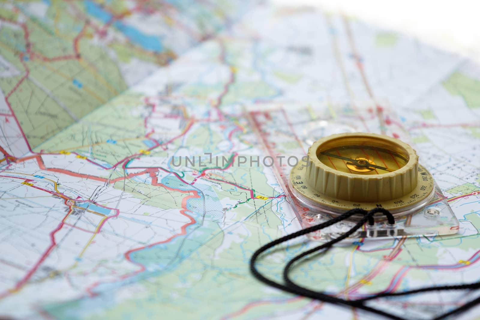 old touristic handheld compass on detailed territory map 