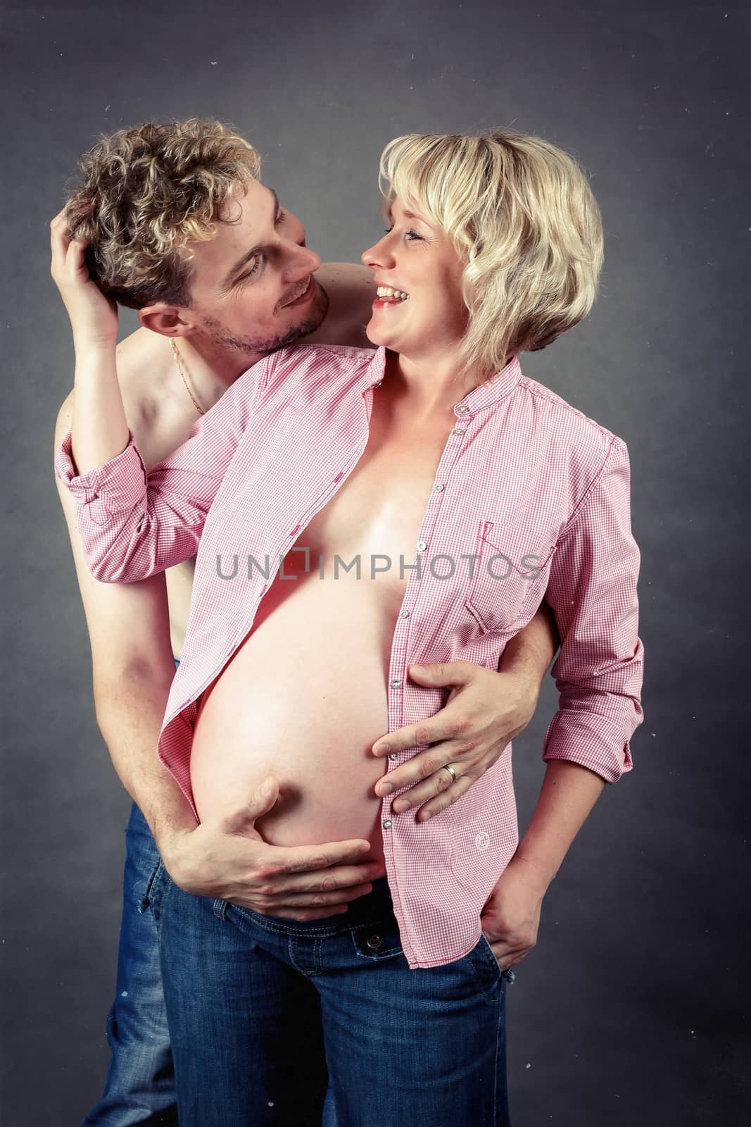 loving happy couple, smiling pregnant woman with her husband, looking at each other