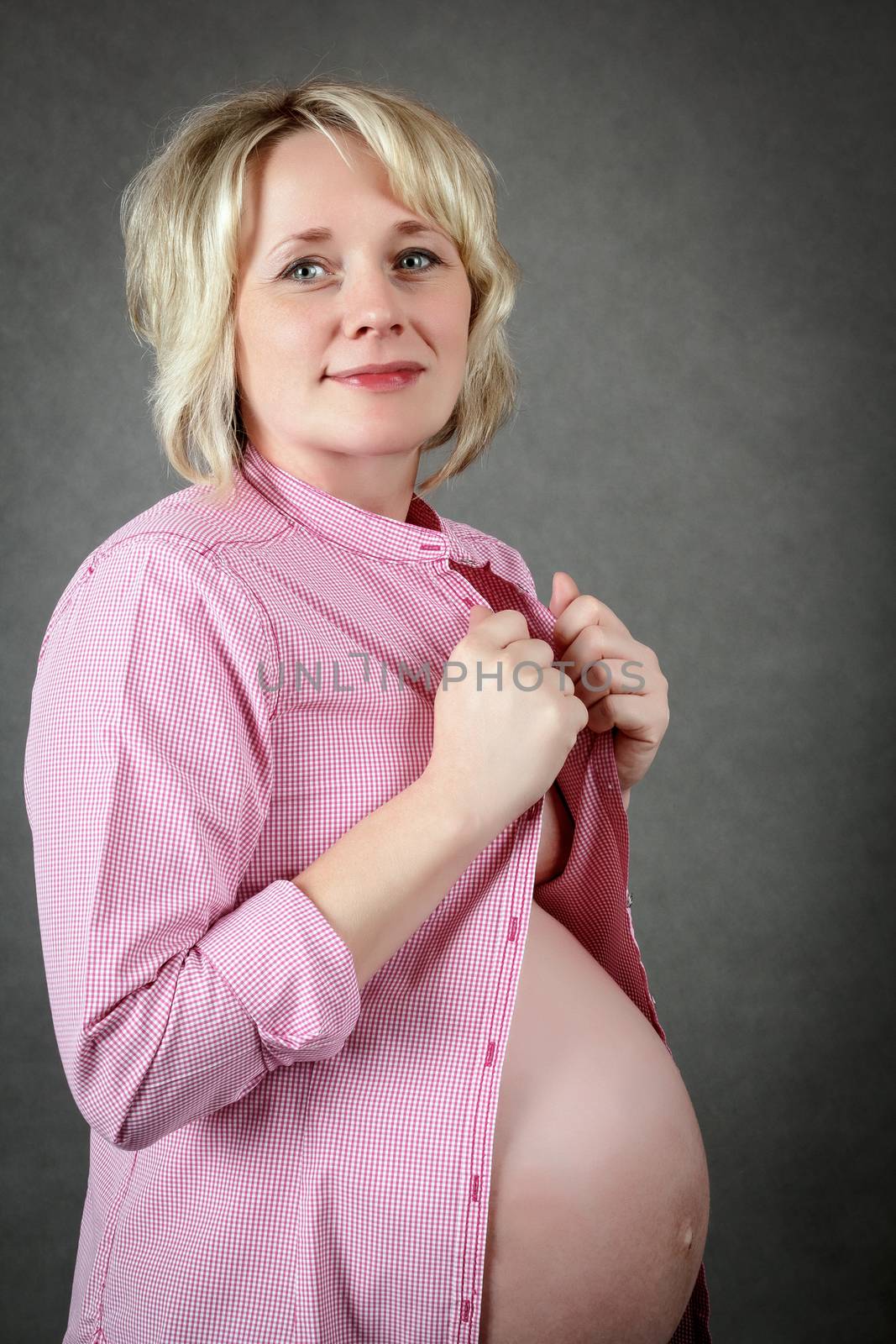 beautiful smiling pregnant woman tenderly holding her tummy