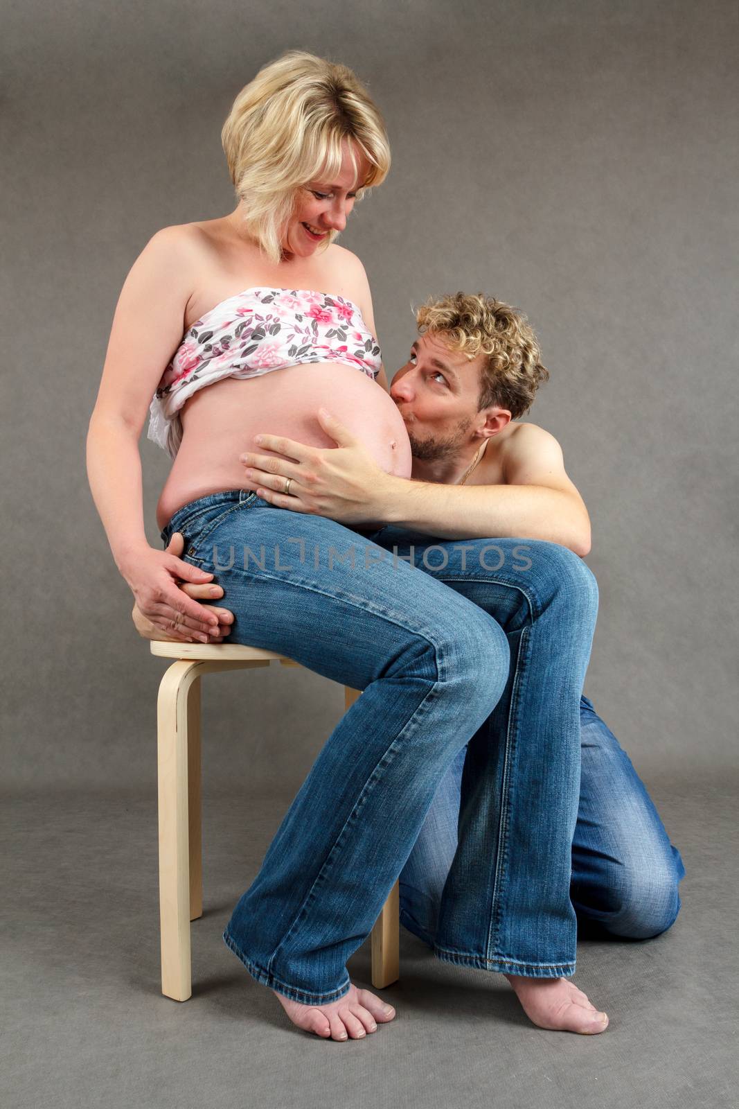 loving happy couple, pregnant woman with her husband, man husband kissing tummy