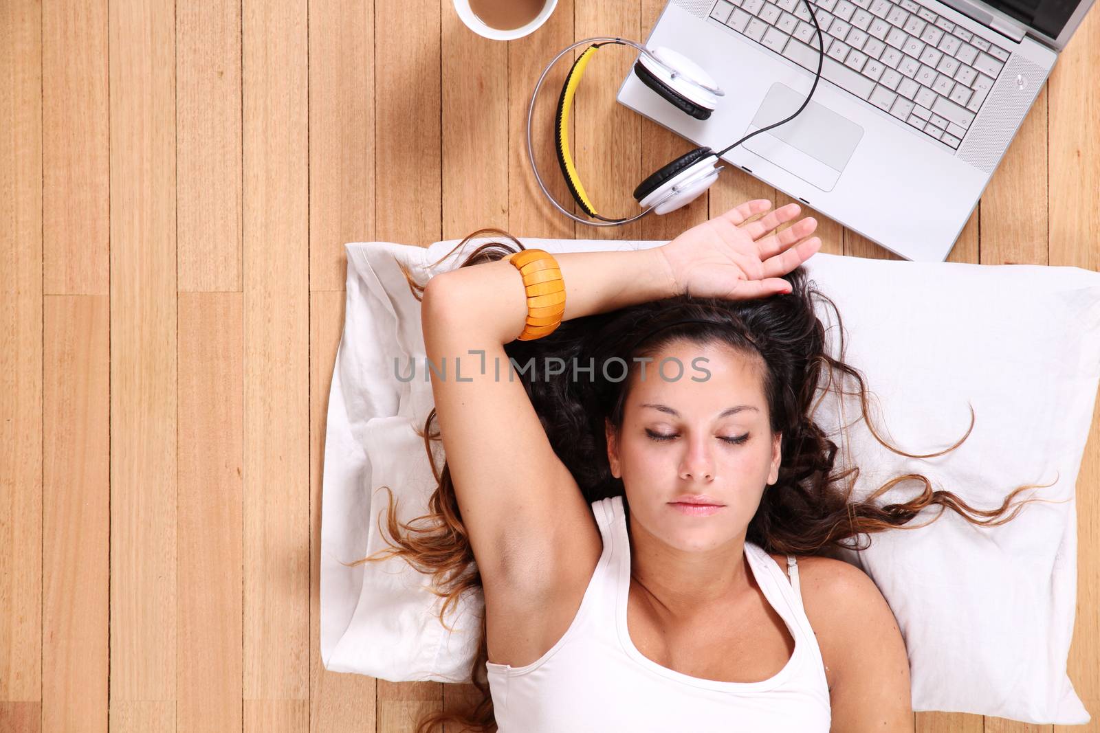 A girl laying on the Floor after surfing on the Internet with a Laptop.