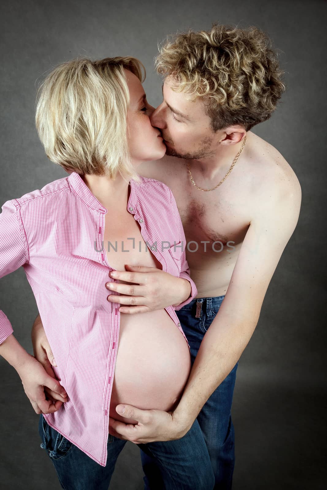 loving happy couple, pregnant woman kissing her husband
