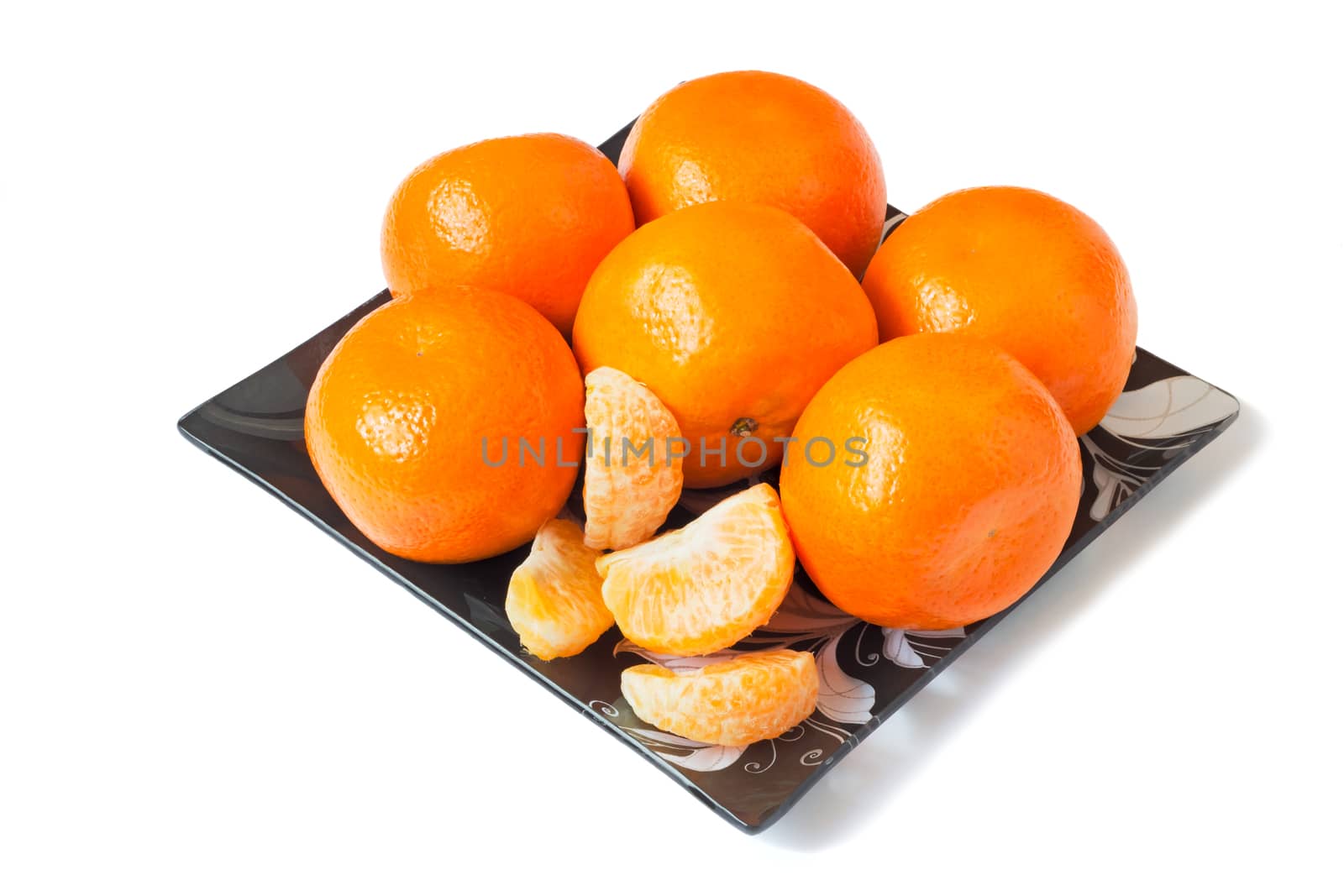 Large ripe oranges are located on a dish made of dark glass with by georgina198