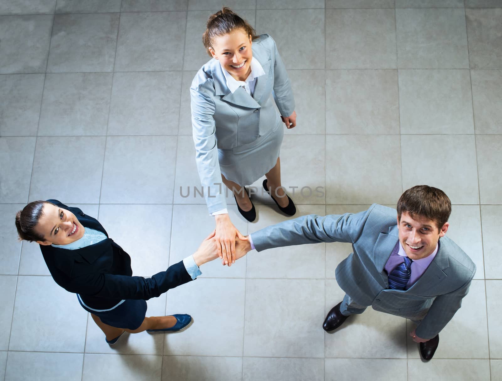 team of three businessmen clasped her hands together, a symbol of teamwork