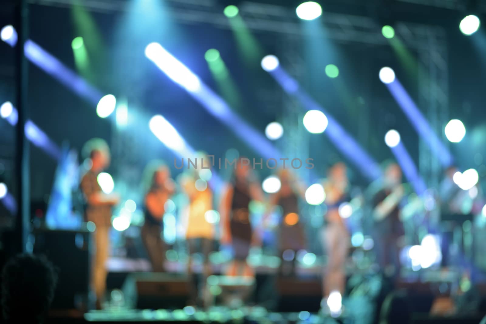 Defocused concert on stage colorful illuminated by Hbak