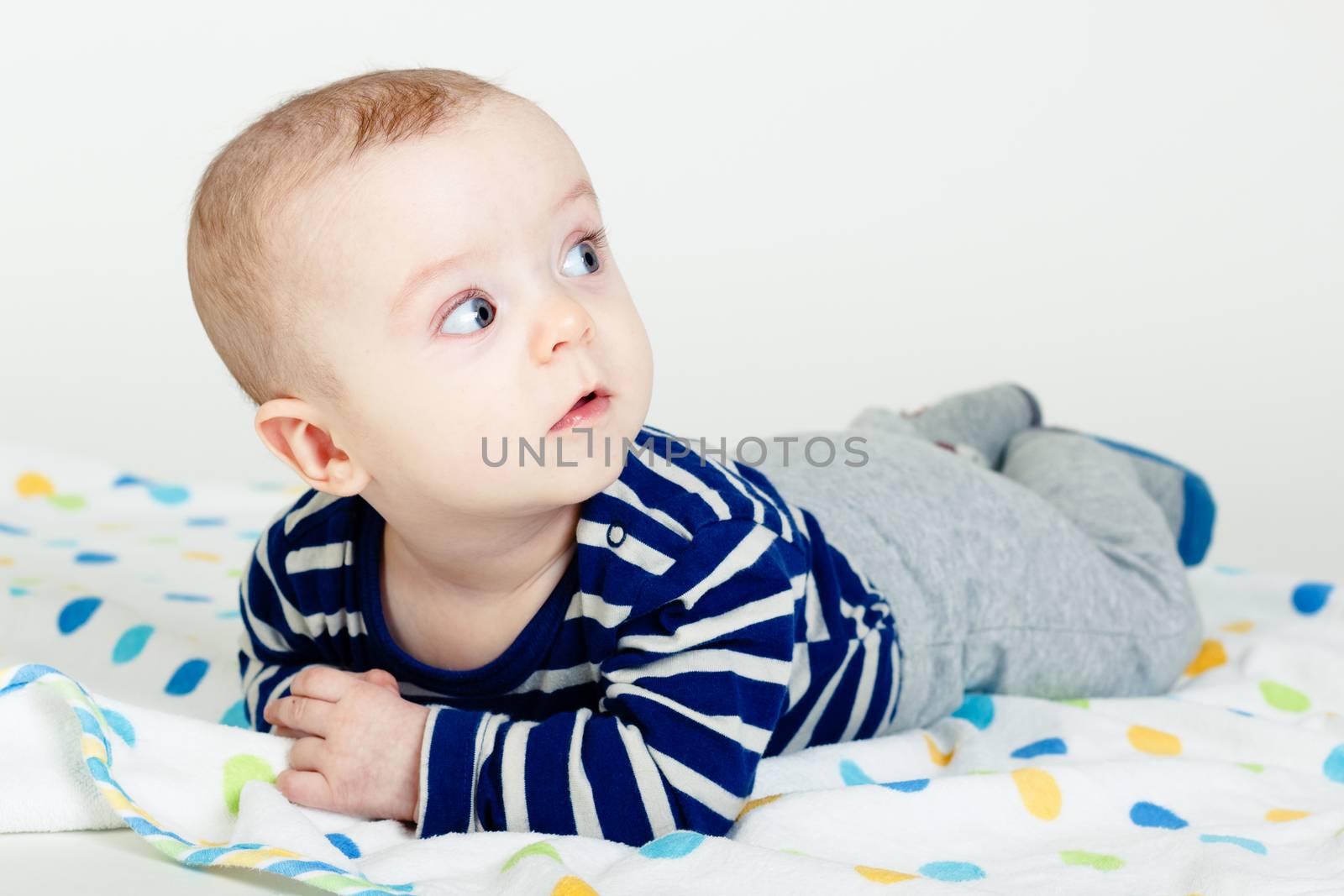 Funny cute blue-eyed baby. Little boy astonished