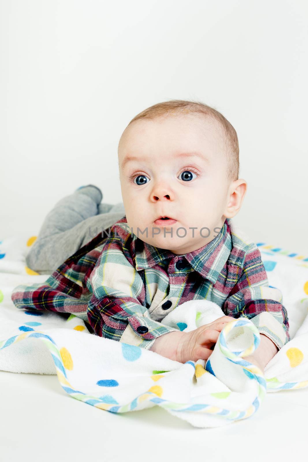 Funny cute blue-eyed baby. Little boy astonished