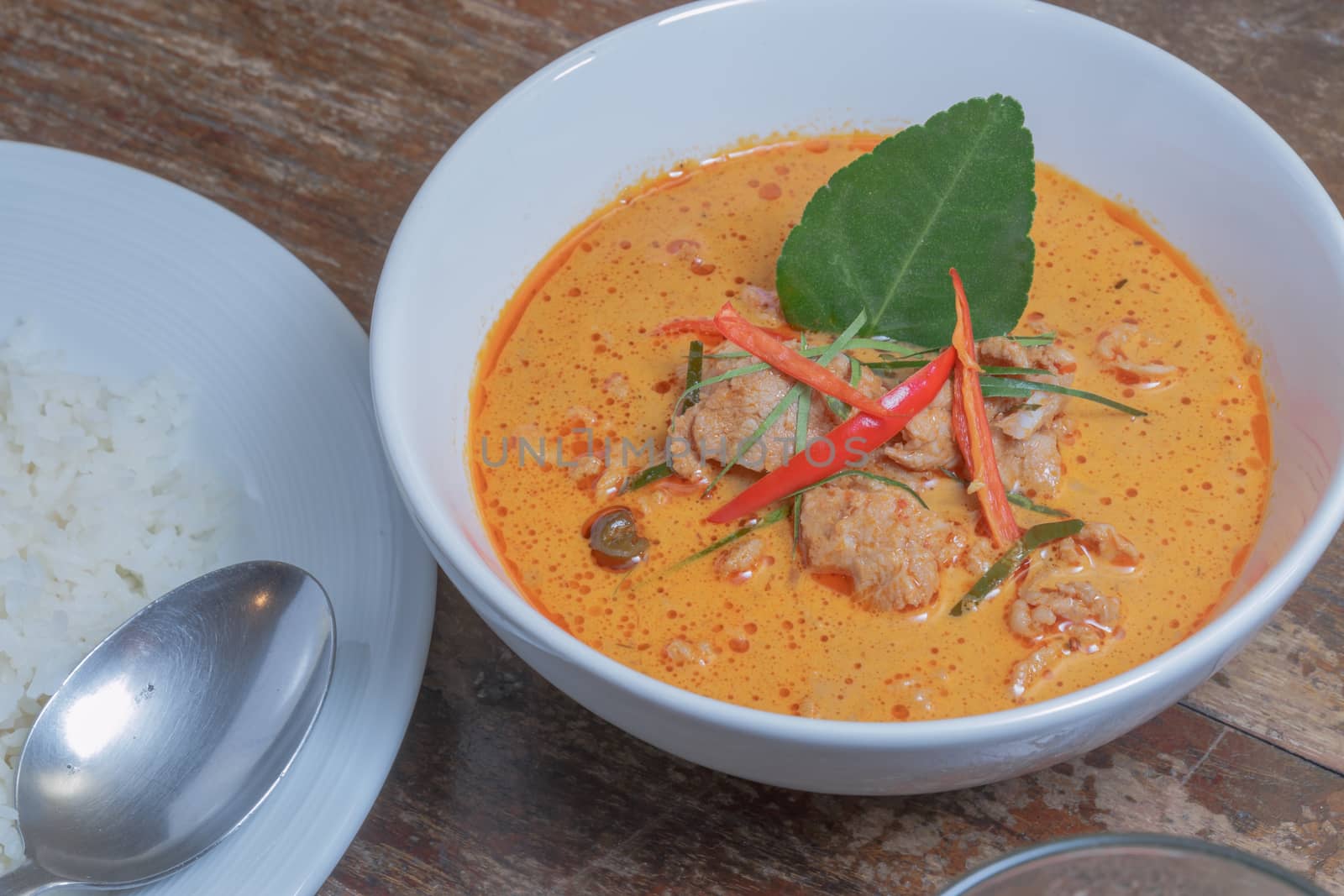 Panang Curry with Pork with rice on wooden table