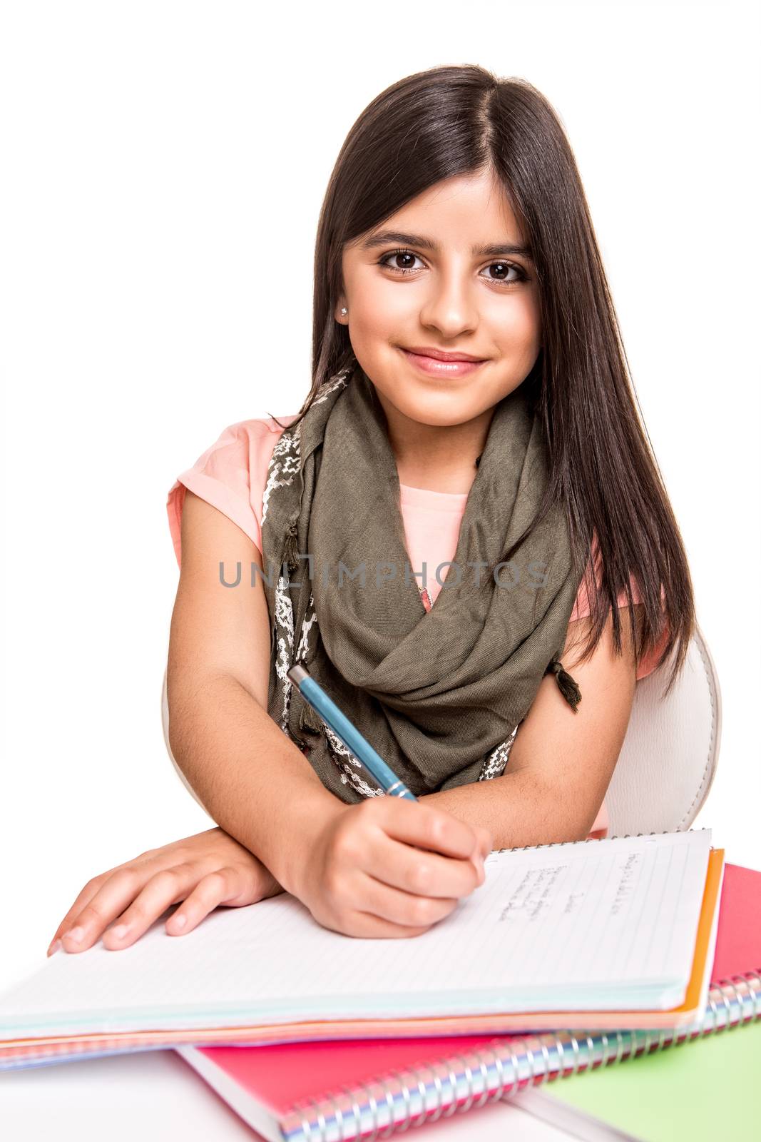 Cute little girl studying and smiling on desk