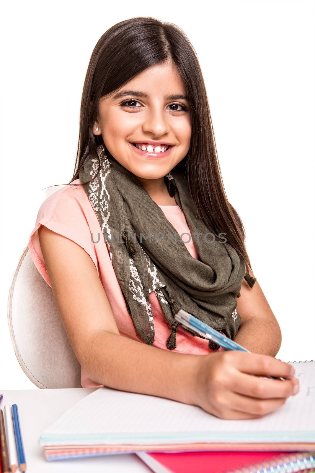 Cute little girl studying and smiling on desk