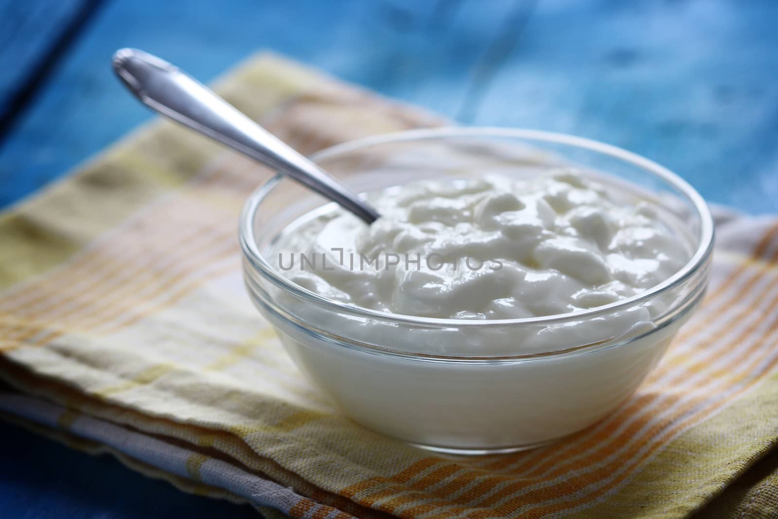 Homemade yogurt in a glass bowl and spoon