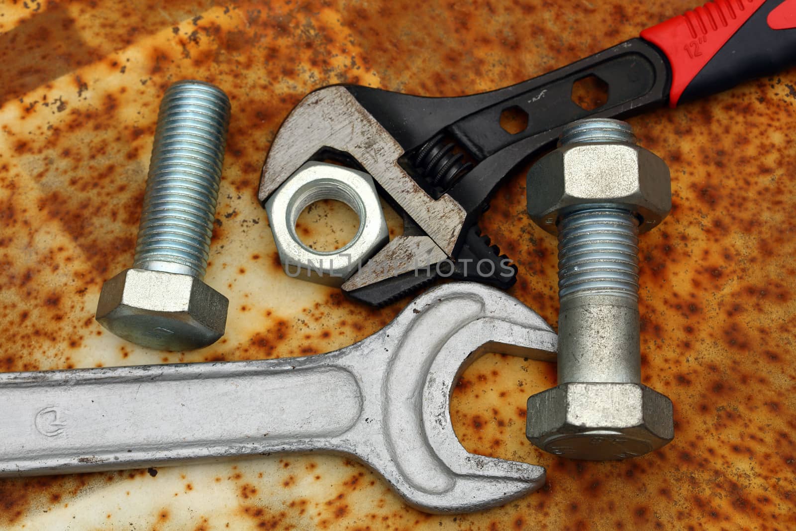 Two wrenches, bolts and nuts close up on rusty grunge  background